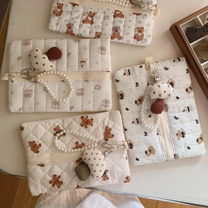 Flat lay of quilted bear cosmetic bags with pearl chains and mushroom charms