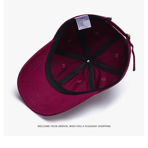Dettaglio interno di un cappello bordeaux in cotone con etichetta JHC e cinturino