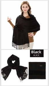 Detail view of black cashmere feel scarf showing soft texture and tassel edges as a shawl