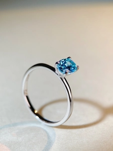 Macro shot of 1 carat blue zircon gemstone with 925 sterling silver four-prong setting