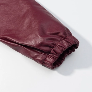 Detail showing elastic cuff and textured burgundy faux leather of the motorcycle jacket