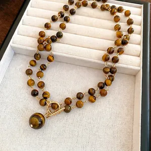 Collana con perline in occhio di tigre con chiusura a T dorata e pendente tondo
