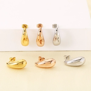 Polished 18k gold teardrop earrings in gold, rose gold and silver finishes on display