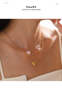 Detail of a 18K gold double-layer necklace with heart pendant and fringe bar design