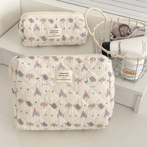 Quilted elephant print cosmetic bag set showing textured cotton fabric and blue bows