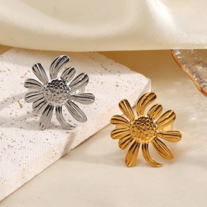 Bague ouverte tournesol minimaliste en or et argent sur un fond élégant à texture fine