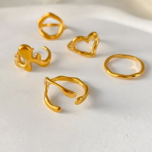 Detailansicht von fünf goldfarbenen unregelmäßigen offenen Ringen im minimalistischen Stil