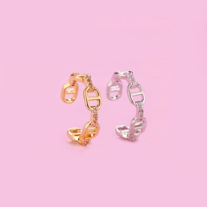Macro shot of pig nose ear cuff earrings with sparkling crystals in gold and silver finish