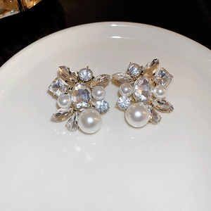 Macro shot of silver-tone earrings featuring sparkling rhinestones and white faux pearls