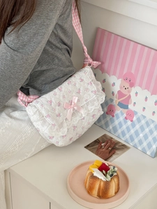 Detail of pink rose floral quilted crossbody bag with lace trim and satin bow