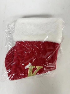 Detailed view of red knitted Christmas stocking with white faux fur and embroidered letter L