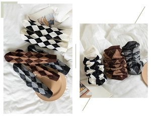 Detailed view of diamond pattern mid-calf cotton socks in black, white, and brown shades