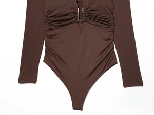Detail of brown nylon bodysuit featuring ruched waist and metal U-shaped front buckle