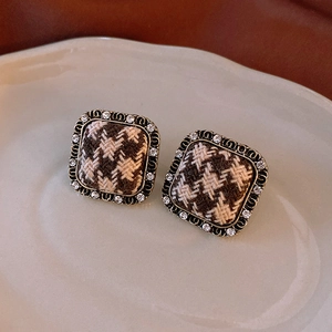 Detail shot of vintage square earrings with houndstooth fabric pattern and crystal frame