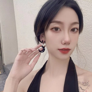 Asymmetric star and moon pearl earrings in black and gold for a trendy minimalist style