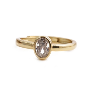 Detailed view of an oval-cut clear zircon stone in a gold-plated adjustable ring
