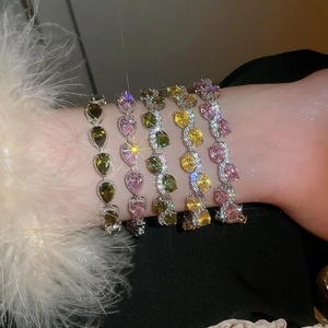 Close-up of sparkling colorful gemstone bracelets with teardrop zircons on a wrist
