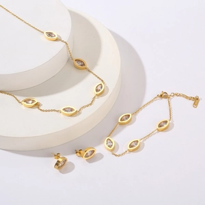 Detail of 18K gold plated jewelry set with white oval stones on white display stands