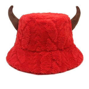 Detailed view of red plush bucket hat with dark brown ox horns and soft faux fur texture