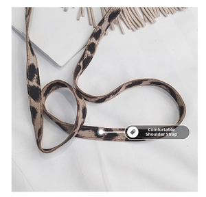 Detail view of leopard print shoulder strap with light apricot tassels on children crossbody bag