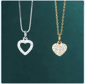 Close-up of heart charms in silver and gold with sparkling cubic zirconia pavé setting
