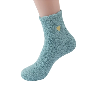 Detail of teal coral fleece slipper socks featuring a gold heart embroidery on the side