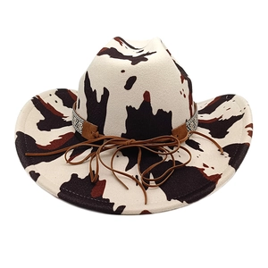 Detail of western cow print cowboy hat with brown leather band and silver metal ornament