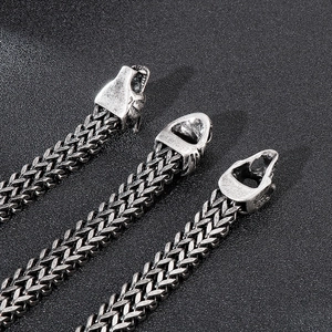 Macro shot of vintage steel braided chain featuring a detailed wolf head clasp buckle