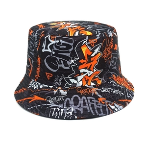 Close-up of graffiti print detail on a black street style bucket hat with orange text