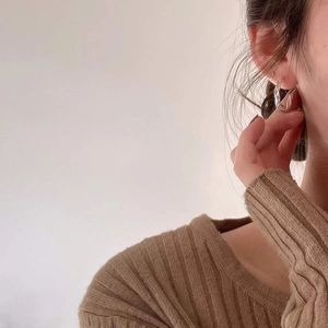 Minimalist 925 sterling silver twisted hoop earrings worn by a model in warm light