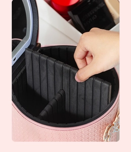 Detalle de los divisores internos ajustables en un maletín de maquillaje de cuero PU rosa.