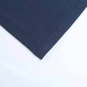 Detailed macro view of navy blue knit dress hemline featuring professional twin needle stitching