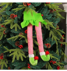 Close-up of green skirt and red striped elf leg decorations on a Christmas tree
