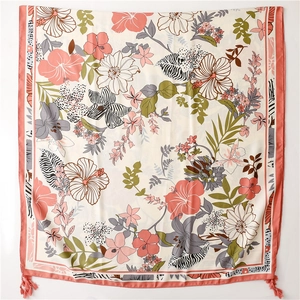 Detail of silk-like beach shawl featuring tropical floral motifs and zebra patterns