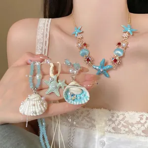 Collier doré élégant avec pendentifs étoile de mer et coquillage, perles et perles bleues