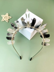 Detail of raw crystal crown with silver wire wrap and moon sun snake metal accents