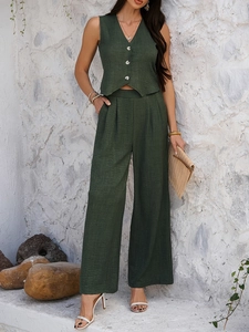 Detail of dark green V-neck vest and high-waist wide-leg trousers in linen cotton blend