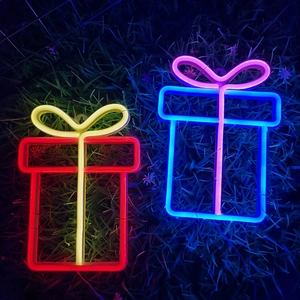 Macro shot of two neon gift box lights in red-yellow and blue-purple on grass