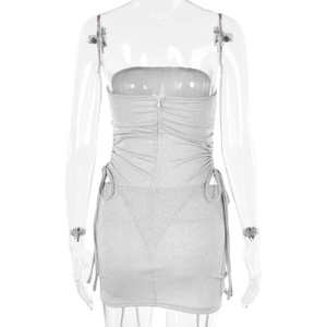 Rear view of silver glitter mini dress featuring back zipper and side drawstring details