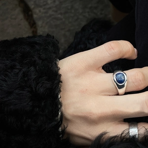 Retro lapis lazuli signet ring in silver finish worn on index finger with fur background