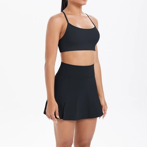 Vue latérale d'un ensemble de yoga noir avec brassière sport et jupe plissée