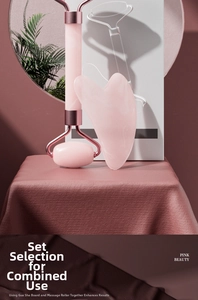 Pink quartz facial roller and heart-shaped gua sha stone set on premium fabric surface