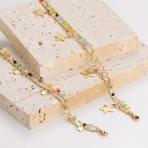 Double-layer gold stainless steel bracelet with star charm and colorful beads on travertine