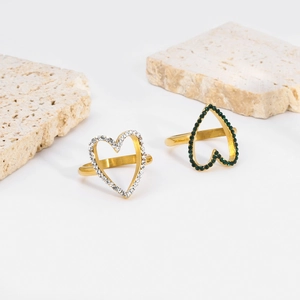 Detail view of 18K gold plated heart rings with white and green stones on stone props