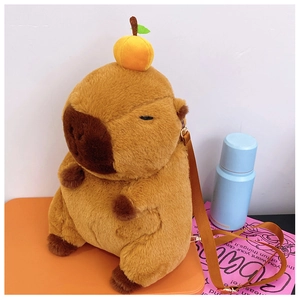 Detail of Capybara plush backpack with orange decoration and adjustable brown strap