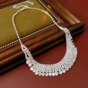 Sparkling multi-layer rhinestone fringe necklace on dark green velvet jewelry tray