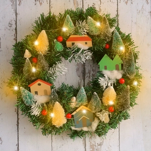 Lighted Christmas wreath with wooden house, colorful pine trees and warm LED string lights