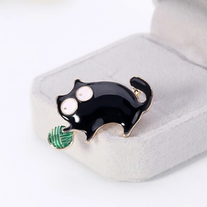 Cartoon black enamel cat brooch with green yarn ball and golden trim detail