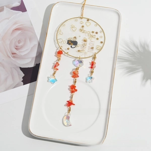 Detail of crystal suncatcher featuring black cat silhouette and reddish natural stones
