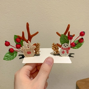 Close-up of reindeer antler hair clips with berries, pine cones and rhinestone charms